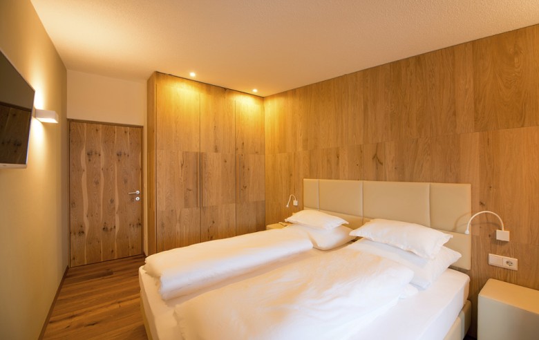 L'immagine mostra un letto matrimoniale e una TV.