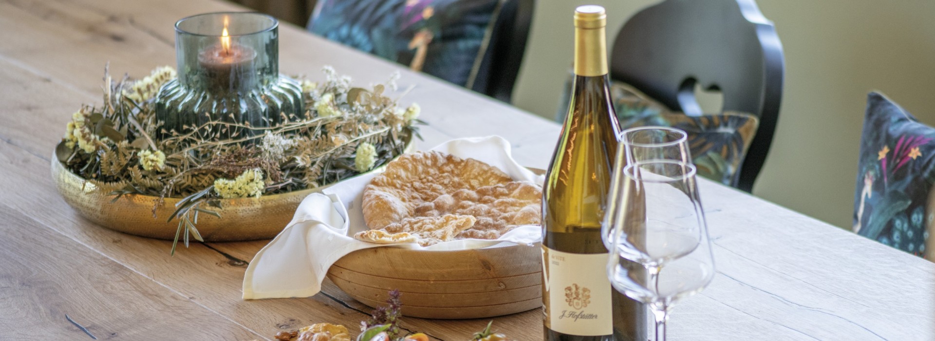 Il tavolo della cucina comune è sempre decorato con cose buone, qui con una bottiglia di vino, il tipico pane duro e una decorazione di candele.