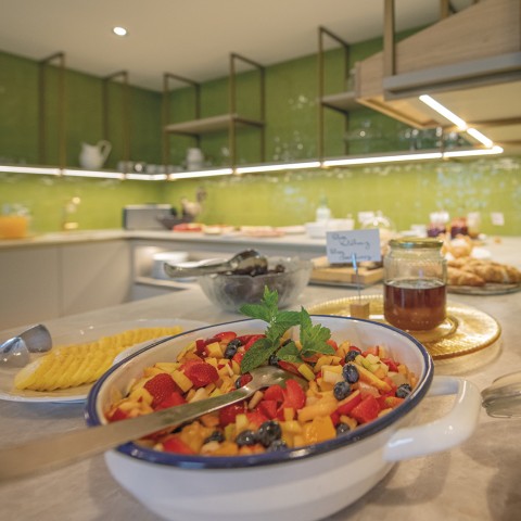 La foto mostra la colazione a buffet. Si possono vedere miele, formaggio e macedonia.