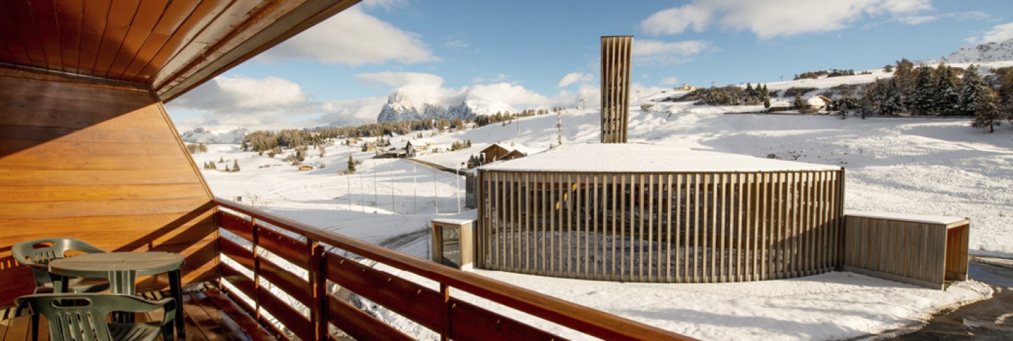 hubertus dolomites a fiè allo sciliar | Vivi l'Alpe di Siusi nei nostri confortevoli appartamenti. Il balcone e la vista dall'appartamento. Sullo sfondo sono visibili le cime del Langkofel e del Plattkofel.