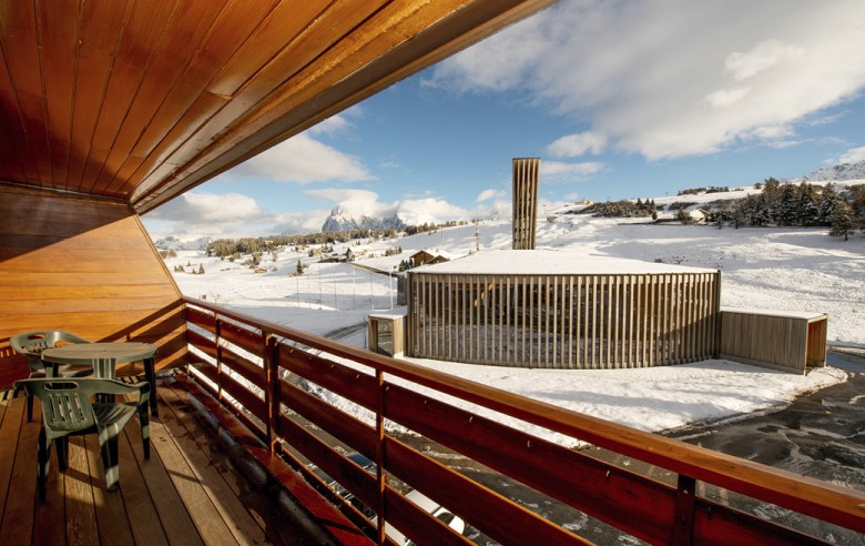 Il balcone e la vista dall'appartamento. Sullo sfondo sono visibili le cime del Langkofel e del Plattkofel.