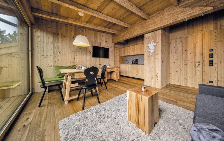 L'area soggiorno dell'appartamento. Si vede un tavolo in legno con sedie nere e la cucina sullo sfondo.