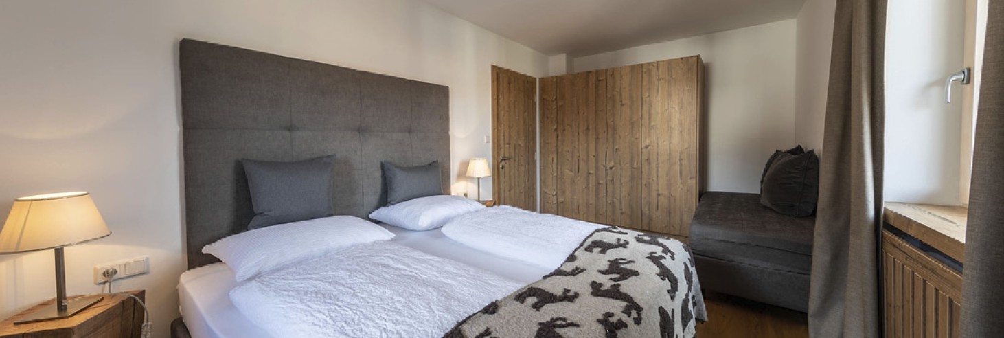 hubertus dolomites a fiè allo sciliar | Pernotta ai piedi dello Sciliar. La camera da letto dell'appartamento vacanze. Sullo sfondo si vedono l'armadio e una zona salotto.