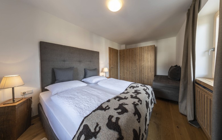 La camera da letto dell'appartamento vacanze. Sullo sfondo si vedono l'armadio e una zona salotto.