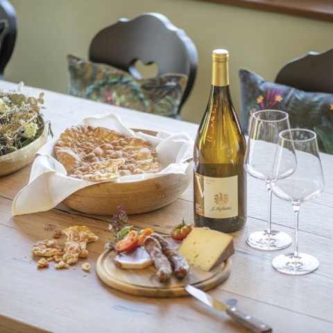 hubertus dolomites Fiè allo Sciliar | Comunità culinaria nella nostra cucina Il tavolo con un merenda e una bottiglia di vino.