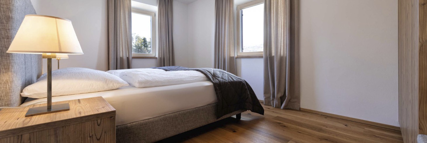 hubertus dolomites a Fiè allo Sciliar | Il tuo appartamento per vacanze familiari nelle Dolomiti. Il letto matrimoniale con due finestre.