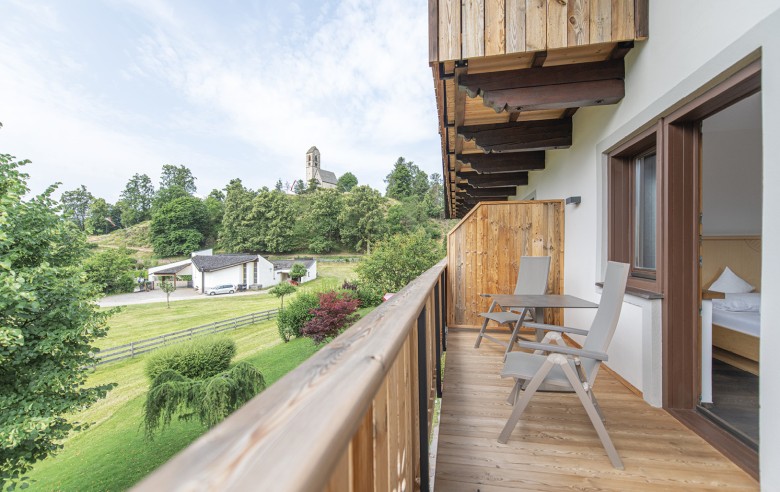 La vista dal balcone offre la tranquillità dei prati circostanti e di una piccola chiesa.