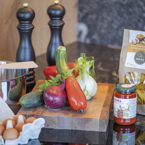 hubertus dolomites Fiè allo Sciliar | nel nostro negozietto direttamente in casa troverete tutto ciò che vi serve Una tavola con verdure, un pacco di pasta, salsa di pomodoro e uova.