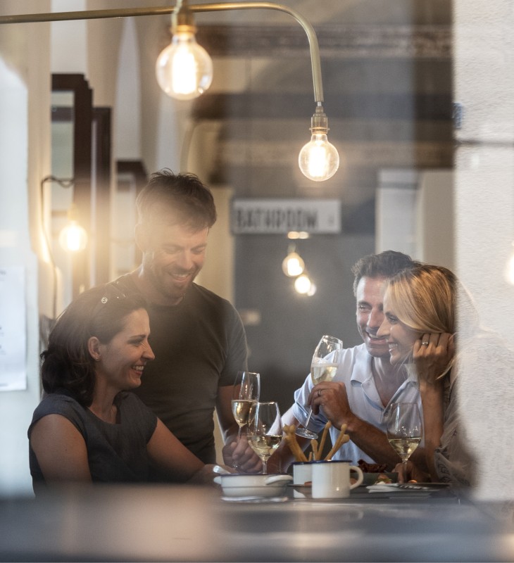 hubertus dolomites Fiè allo Sciliar | Esperienze indimenticabili Fiè allo Sciliar Due coppie che bevono Prosecco insieme in un bar.