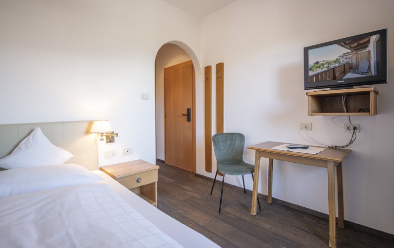La camera single accogliente con letto singolo, scrivania e televisore.