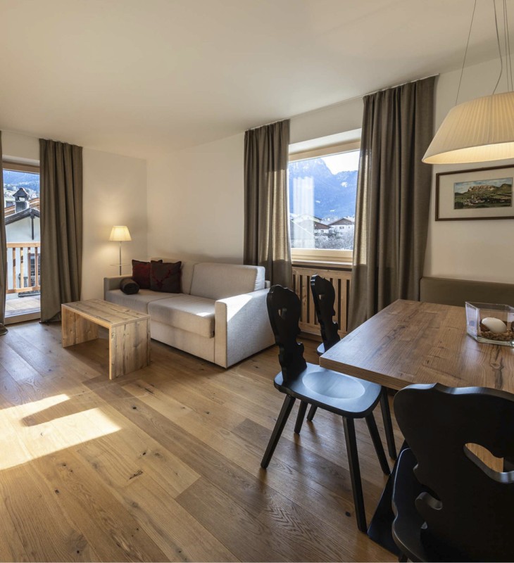 Il chiaro soggiorno di un appartamento con divano e tavolo da pranzo.