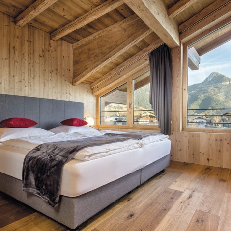 Una stanza con un letto e cuscini rossi.