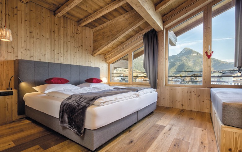 Una stanza con un letto e cuscini rossi.