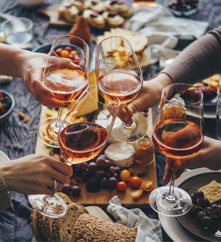 hubertus dolomites Fiè allo Sciliar | Piacere gastronomico sull'Alpe di Siusi Un tavolo da pranzo con marende e cesti di pane. Gli ospiti brindano con i loro aperitivi.