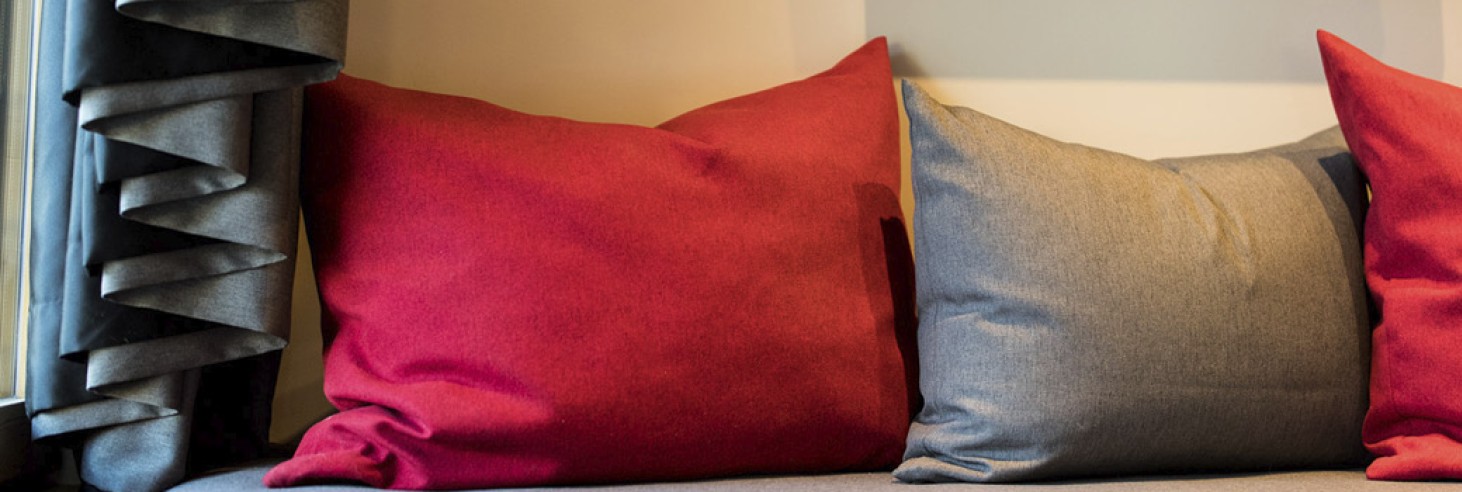 hubertus dolomites a Fiè allo Sciliar | Un rifugio nel cuore delle Dolomiti. Un dettaglio del divano con cuscini rossi e grigi.