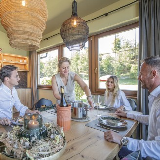 hubertus dolomites Völs am Schlern | Il gusto è migliore insieme: scoprite la nostra cucina comune Una famiglia al tavolo da pranzo nella cucina comune.