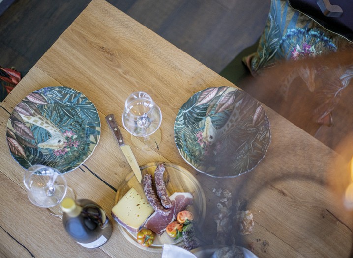 L'immagine mostra il tavolo apparecchiato nella cucina comune con una merenda tipica dell'Alto Adige.