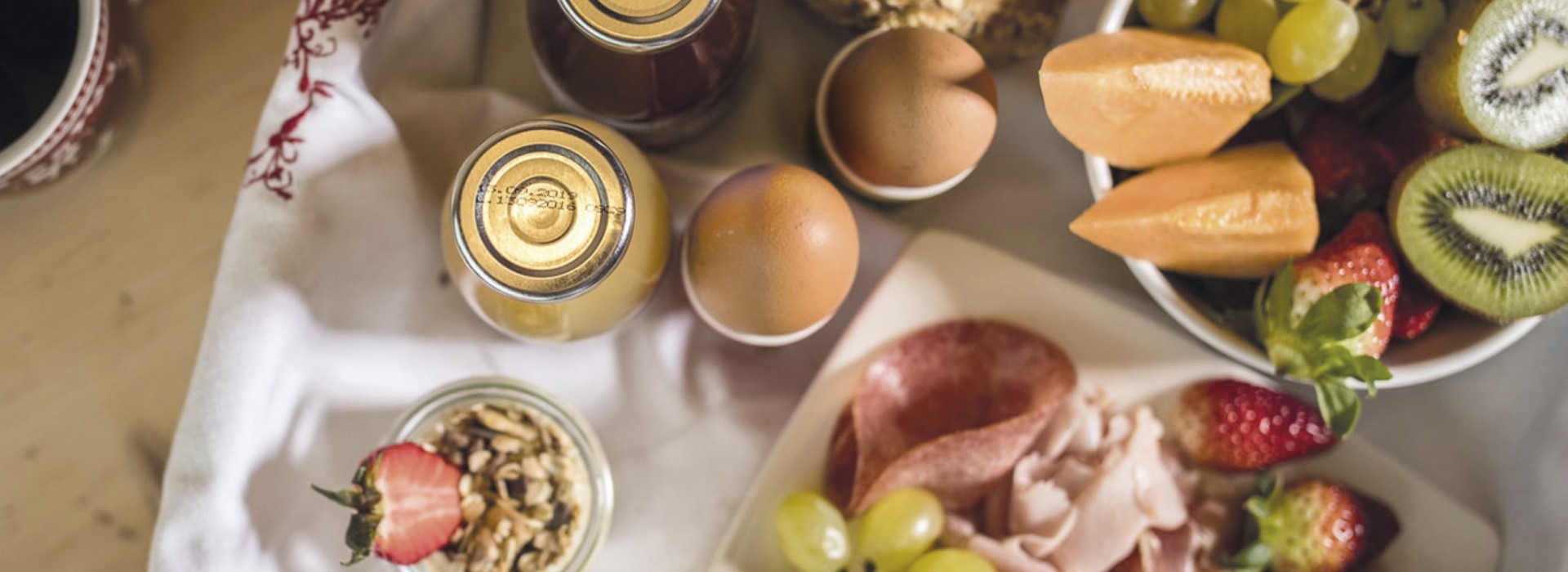 La colazione a buffet con yogurt, uova, succhi, frutta e pane.